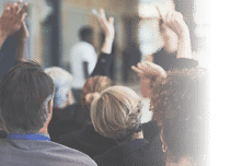 Shot of a group of businesspeople raising their hands to ask questions during a conference
