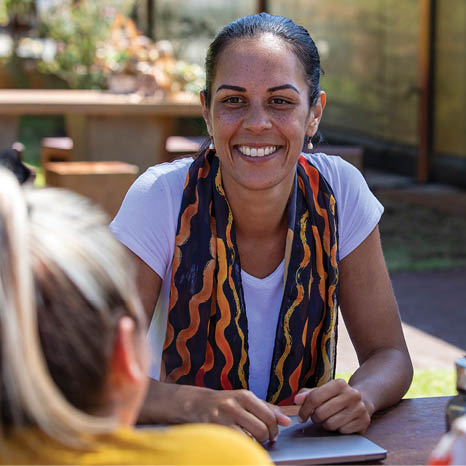 Close-up of young aboriginal students studying together outdoors in the sun in Australia 