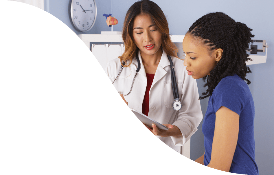 African American patient explaining issues to Asian doctor using tablet